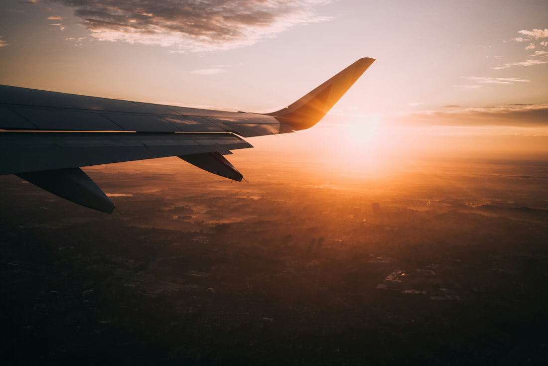 Plane flying at sunset